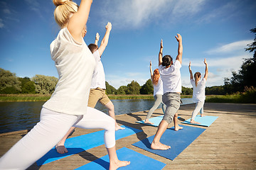 Image showing group of people making yoga exercises outdoors