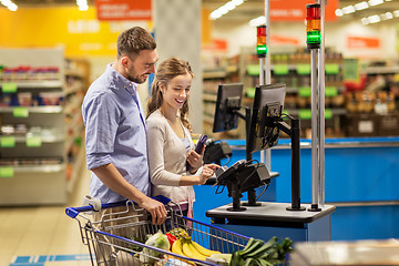 Image showing couple buying food at grocery at cash register