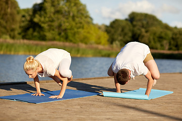 Image showing couple making yoga crow pose outdoors