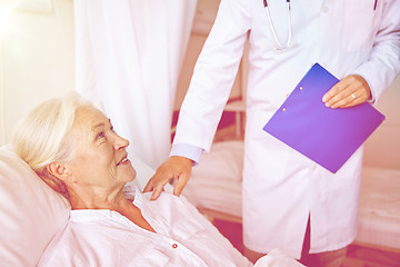 Image showing doctor visiting happy senior woman at hospital