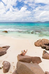 Image showing Woman reading book on picture perfect beach Anse Patates on La Digue Island, Seychelles.