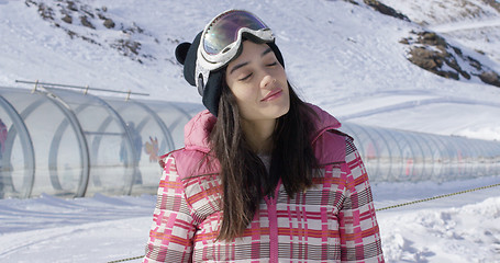 Image showing Young woman relaxing on ski slope in winter