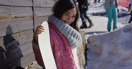 Image showing Smiling mixed race girl standing with snowboard