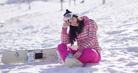 Image showing Young woman on ski slope with snowboard