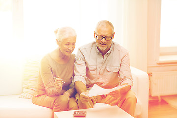 Image showing senior couple with papers and calculator at home