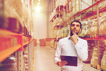 Image showing businessman with clipboard at warehouse