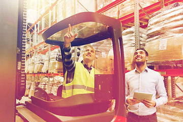 Image showing men with tablet pc and forklift at warehouse