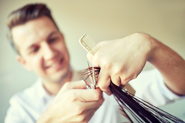 Image showing stylist with scissors cutting hair tips at salon