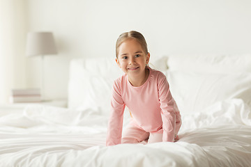 Image showing happy little girl on bed at home bedroom