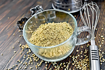 Image showing Flour hemp in glass cup with mixer on dark board