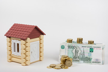 Image showing Near the toy house is a lot of money on buying a home, white background