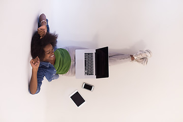 Image showing african american woman sitting on floor with laptop top view