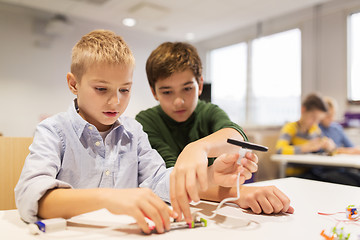 Image showing happy children building robots at robotics school