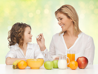 Image showing happy mother and daughter eating healthy breakfast