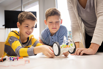 Image showing happy children building robot at robotics school