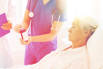 Image showing doctor giving medicine to senior woman at hospital