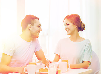 Image showing smiling couple having breakfast at home