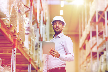 Image showing happy businessman with tablet pc at warehouse