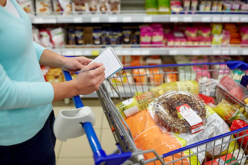 Image showing woman with food in shopping cart at supermarket