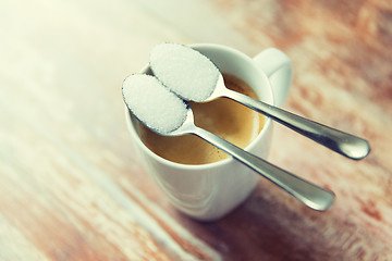 Image showing close up of white sugar on teaspoon and coffee cup