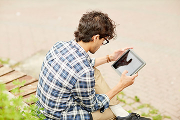 Image showing man with tablet pc sitting on city street bench