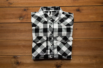 Image showing checkered shirt on wooden background