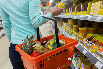 Image showing woman with food basket and jar at grocery store