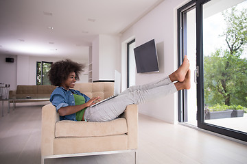 Image showing African American women at home in the chair using a laptop