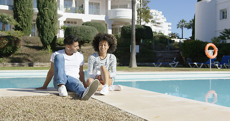 Image showing Young couple relaxing alongside an urban pool