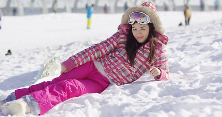 Image showing Young woman in pink snowsuit with ski goggles