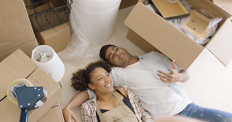 Image showing Attractive couple lying on the floor of their home