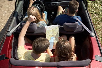 Image showing happy friends with map driving in convertible car