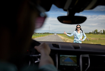 Image showing woman hitchhiking and stopping car with thumbs up