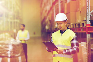 Image showing man with clipboard in safety vest at warehouse