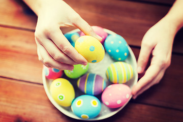 Image showing close up of woman hands with colored easter eggs