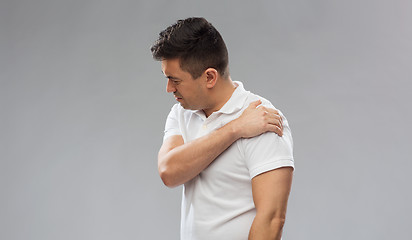 Image showing unhappy man suffering from pain in shoulder