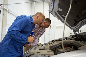 Image showing auto mechanic with clipboard and man at car shop