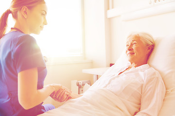 Image showing doctor or nurse visiting senior woman at hospital