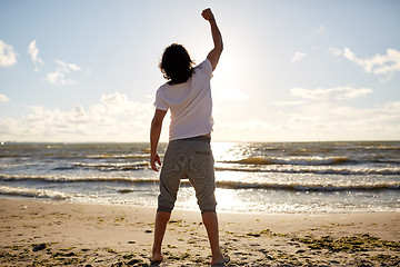 Image showing man with rised fist on beach