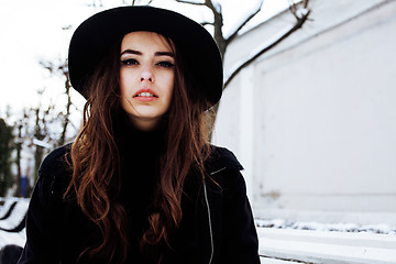 Image showing young pretty modern hipster girl waiting on bench at winter snow park alone, lifestyle people concept