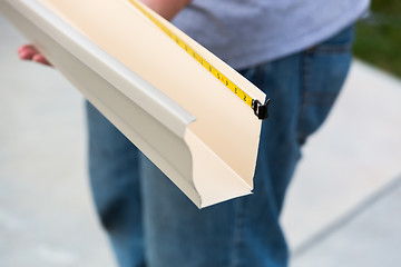 Image showing Worker Measuring Rain Gutter Processing Through Seamless Shaping