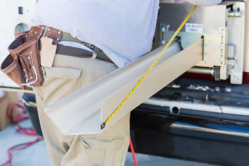 Image showing Worker Measuring Rain Gutter Processing Through Seamless Shaping