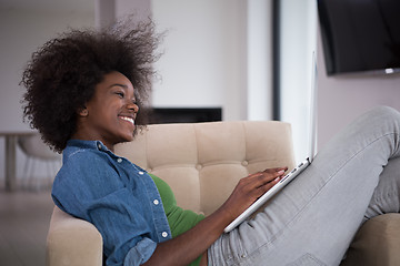 Image showing African American women at home in the chair using a laptop