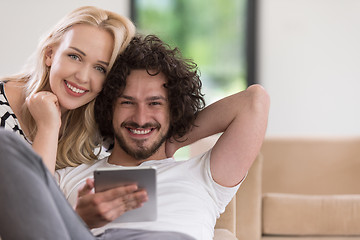 Image showing couple relaxing at  home with tablet computers