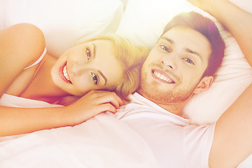 Image showing happy couple lying in bed at home