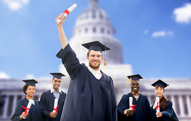 Image showing happy students in mortar boards with diplomas