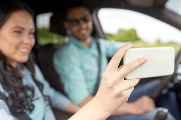 Image showing couple driving in car and taking smartphone selfie