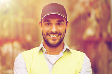 Image showing happy man in reflective safety vest at warehouse