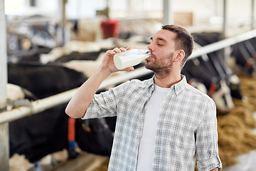 Image showing man or farmer drinking cows milk on dairy farm