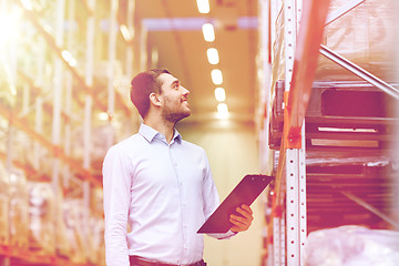 Image showing happy businessman with clipboard at warehouse